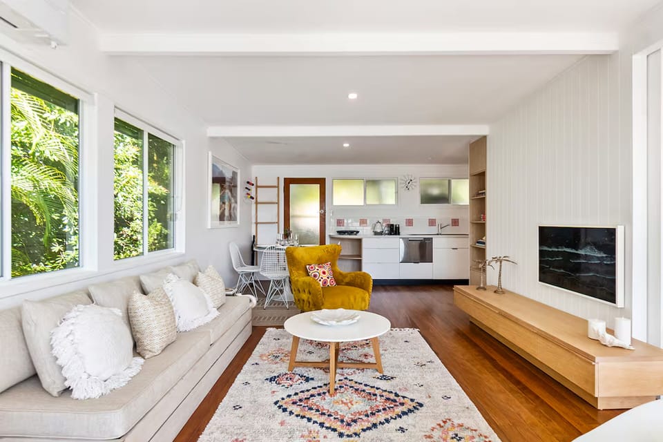 Open-plan lounge links kitchen, dining, Smart TV and balcony outlook near Noosa.