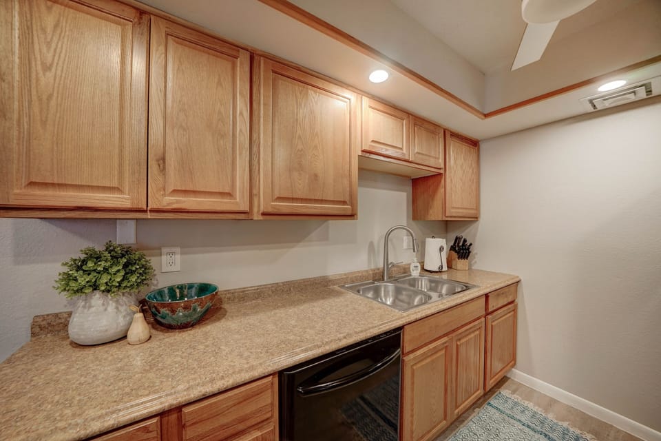 Galley style kitchen has a dishwasher, refrigerator, stove and microwave