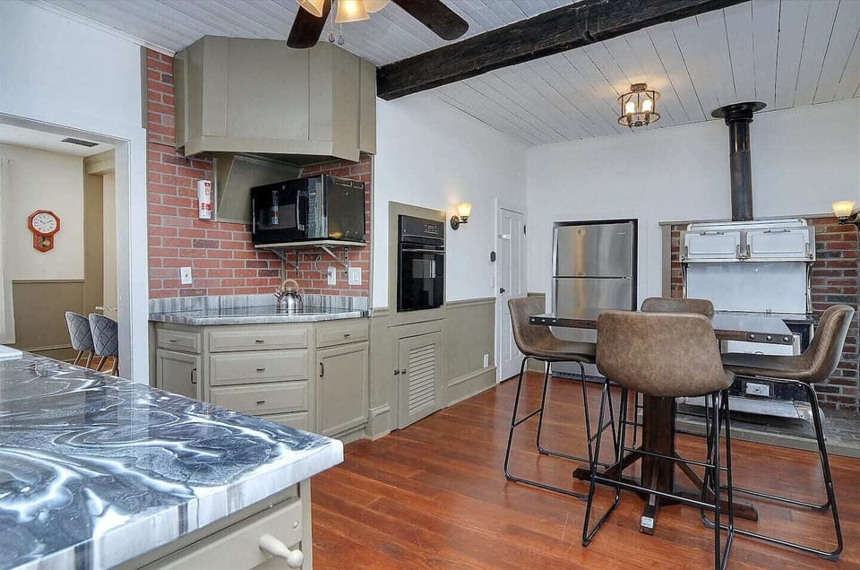 - Inviting kitchen nook with seating for four and a decorative vintage oven centerpiece
- Exposed beams, rich hardwood floors, and brick accents deliver timeless character
- Spacious and stylish for both everyday meals and special get togethers

