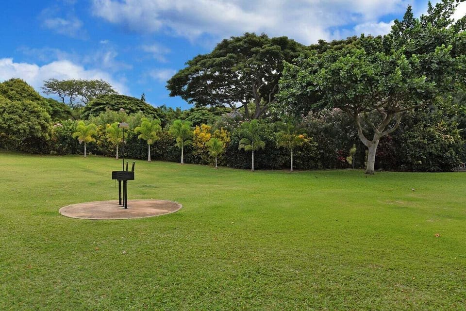 Lawns stretch beneath trees, grills waiting in the quiet green.