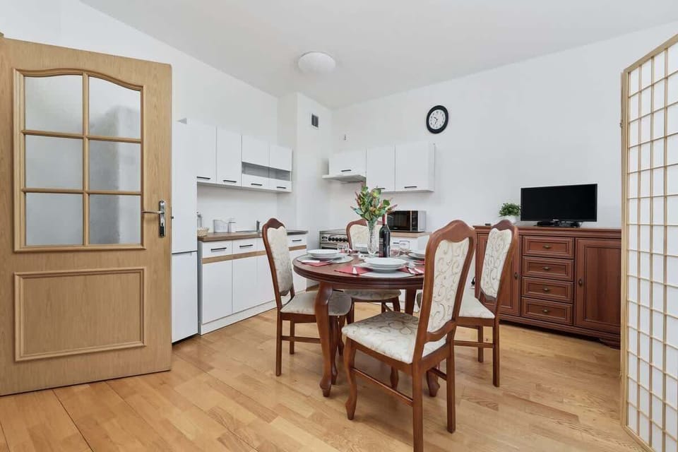 A well-lit dining corner with a round table and elegant table settings.
