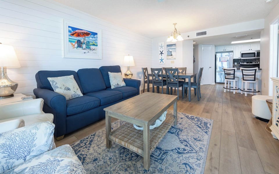 Inviting living area with a plush sofa with a queen sleeper, coastal decor, and a dining table perfect for family meals