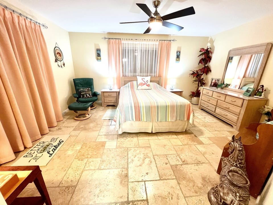 Master Bedroom with Queen bed has sliding glass door views to the pool & lake. 
