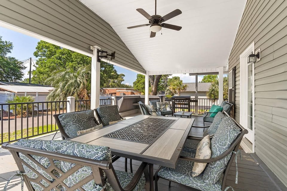 Spacious covered patio with cozy seating and ceiling fan