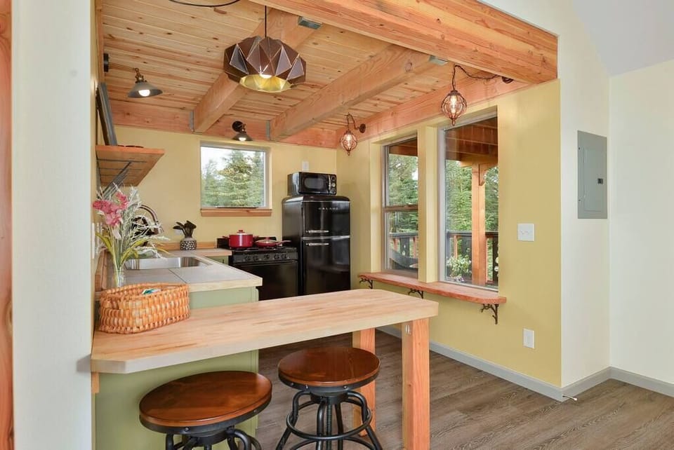 The kitchen is full equipped with pots, pans and dishes. 