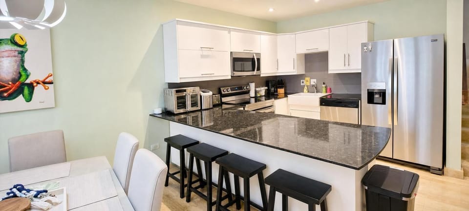 A cozy open kitchen with bar stools and a dining area