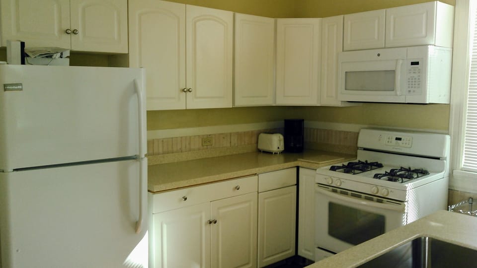 Kitchen with full size refrigerator/freezer with ice maker, full size stove