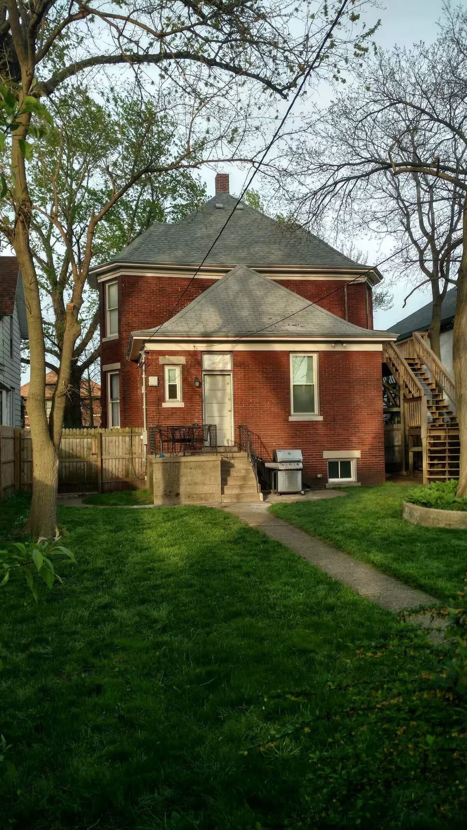 Rear yard, fully fenced with mature trees,  back entrance, grill, seating.