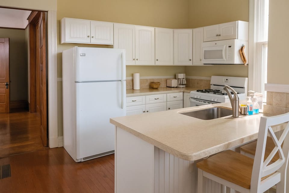 Additional view including sink, island, bar stools and entry to dining room