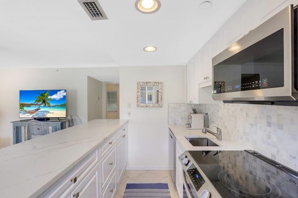 Kitchen is fully updated with white quartz countertops, marble backsplash, etc.!