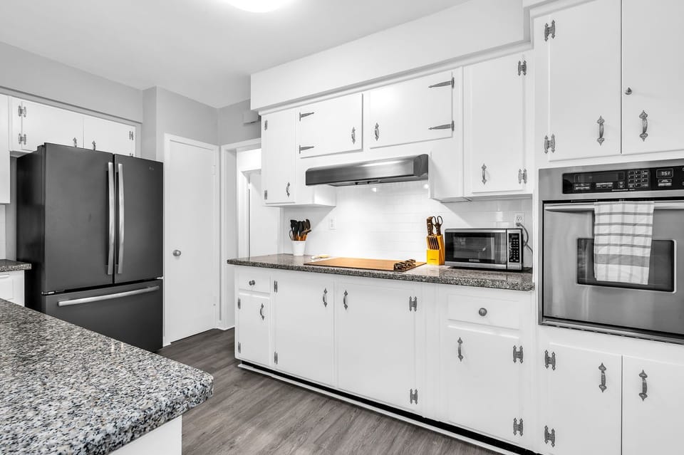 The kitchen has a unique antique feel with the original cabinetry. Upgraded with new flooring and black granite countertops. Fully equipped with everything you need to create a lovely meal for friends and family.