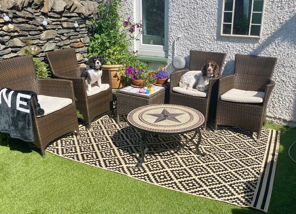 Westerly very sunny back garden with garden furniture.