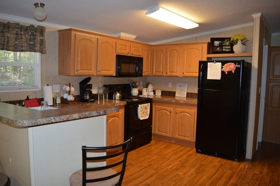 L shaped kitchen with electric oven/stove, full size fridge, and dishwasher. 