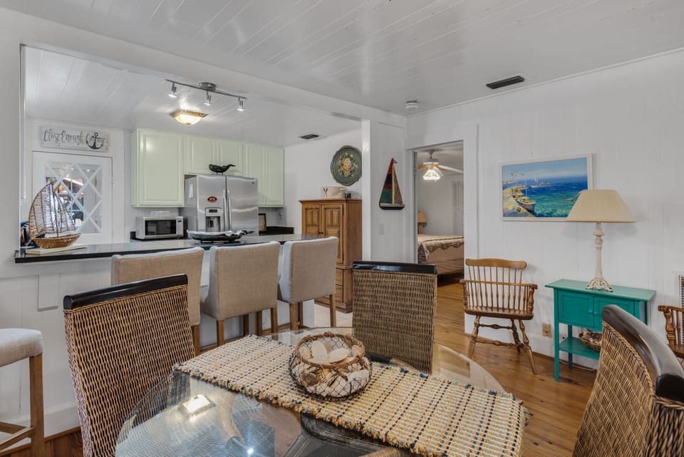 4 chairs at the dining table, 3 bar stools at the bar, view into Master Bedroom 