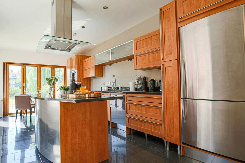 A fully equipped kitchen with fridge freezer, oven, stove, microwave, dishwasher, kettle, toaster, cookware, tableware, and utensils all provided