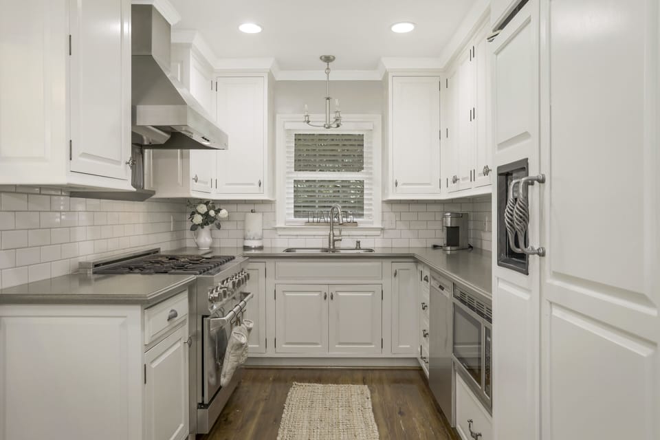 Chef's kitchen with 36in commercial range and modern finishes.