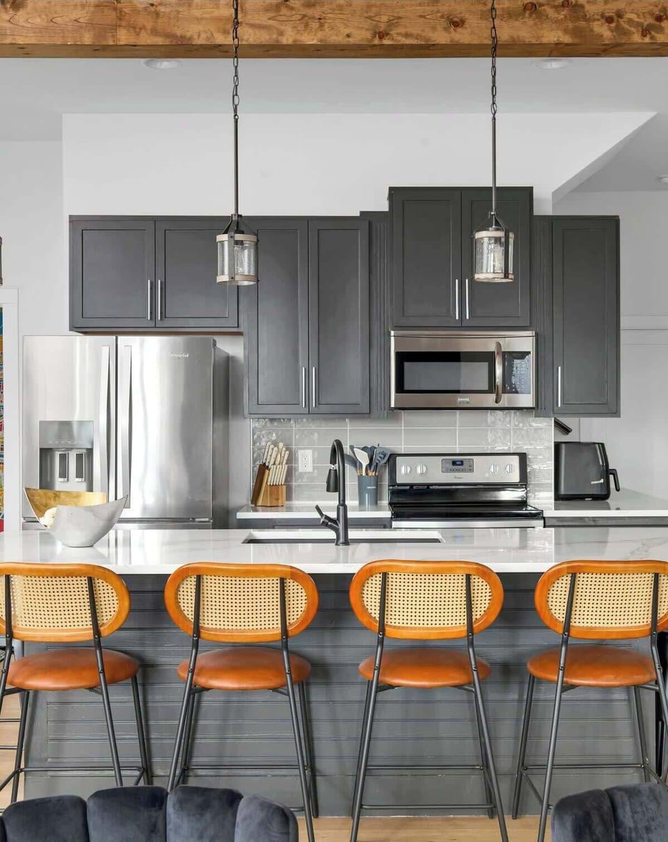 Modern island kitchen counter paired with stylish brown chairs.