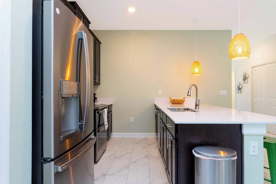 Sleek kitchen view with stainless appliances, pendant lighting, and a spacious island with seating-stylish and ready for casual meals or entertaining!