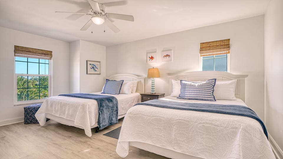 Bedroom 3: two queen beds in serene coastal tones.