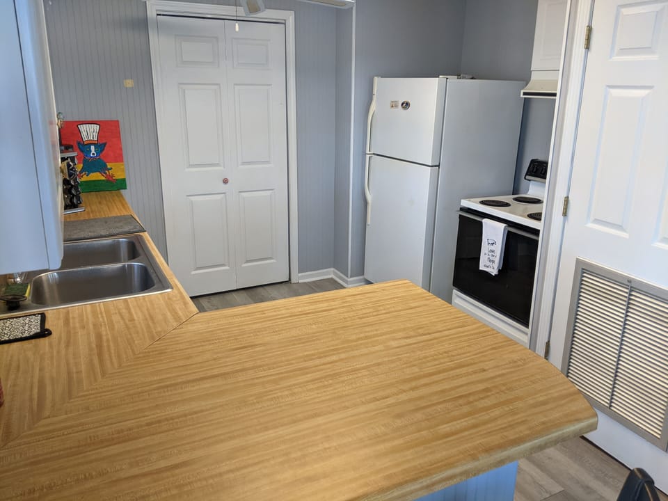 Kitchen w/ fridge/freezer, coffee pot, dishwasher, 2 bar  stools, eat in area.