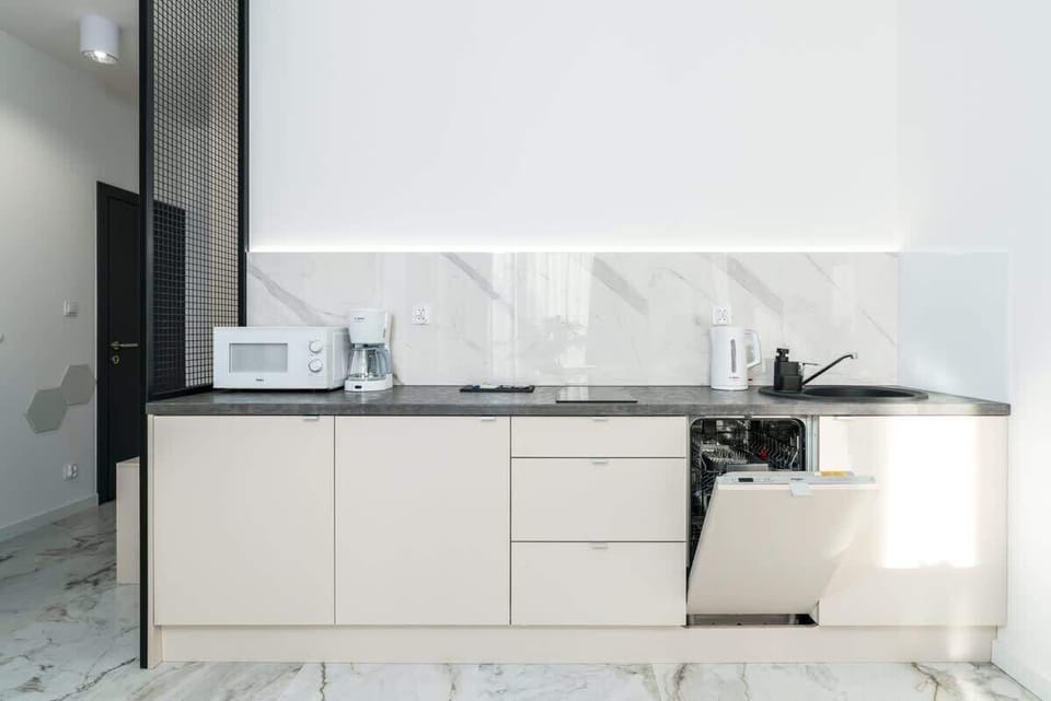 Kitchenette with plenty of kitchen utensils and dishes. 