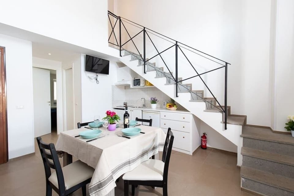 Living area with fully equipped kitchen, dining table, sofa and TV with Netflix