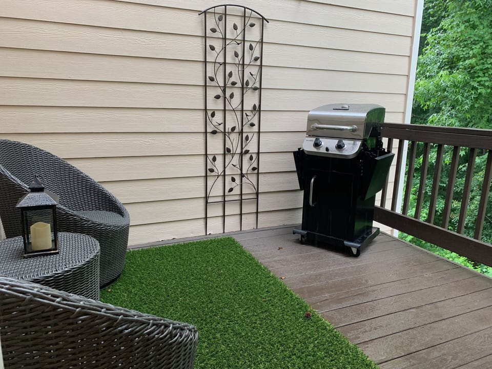 2nd floor private outdoor deck with seating and gas grill.