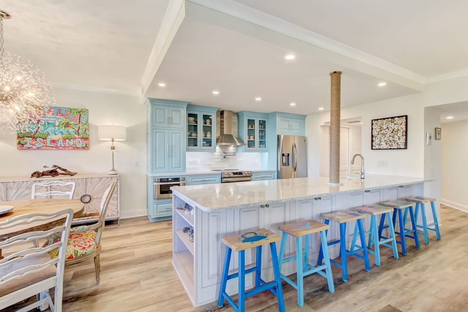 Luxury Chef's Kitchen with Quartz Countertops, Designer Cabinetry, a Farmhouse Sink, Stainless Steel Appliances, and Barstool Seating for 6