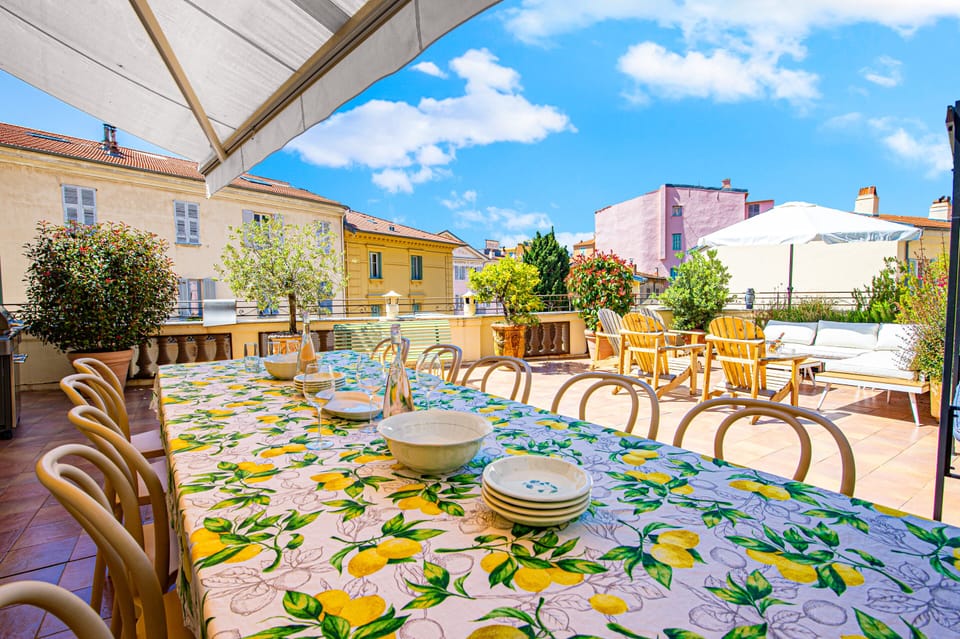 Terrace set up for guests' comfort with barbecue, dining table and benches.