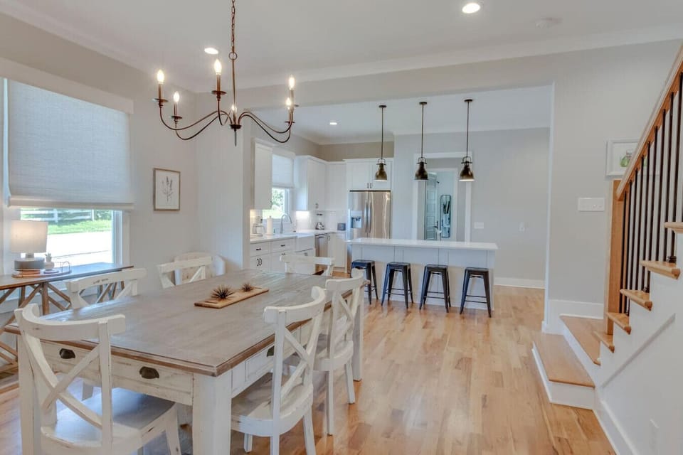 A bright dining room with a statement chandelier and farmhouse table seats the whole group comfortably.