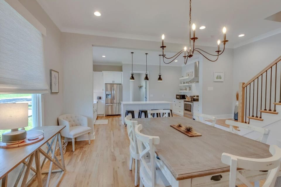 A full view of the farmhouse kitchen shows the white cabinetry, open shelving, and stainless appliances.