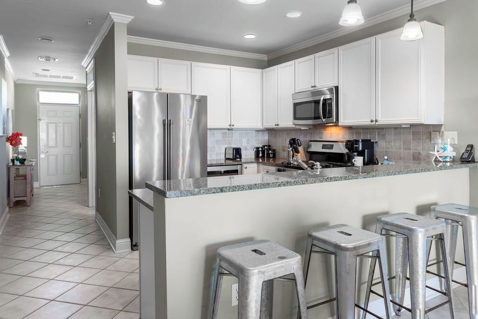 Kitchen - The fully stocked kitchen features an eat-in style bar with seating.