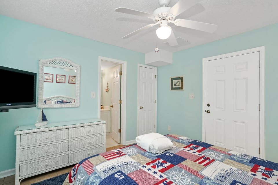 Drift off in your cheerful coastal bedroom with soothing mint walls, crisp white wicker furnishings, and a ceiling fan for gentle breezes.