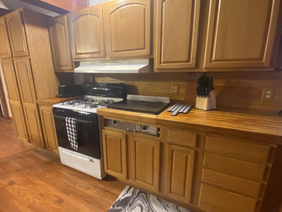 Kitchen complete with a stove/oven and a built in griddle 