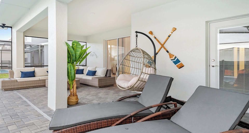 Relaxing covered patio with lounge chairs, hanging swing, and cozy outdoor seating.
