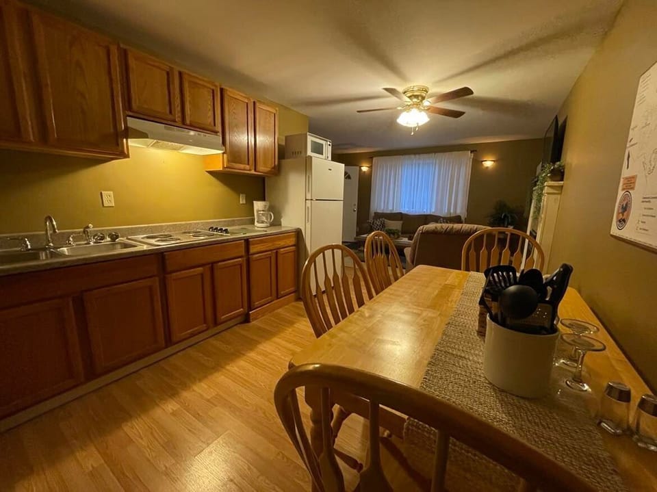 Kitchen offers stove & full size refrigerator, dinning table, pots, pans, dishes