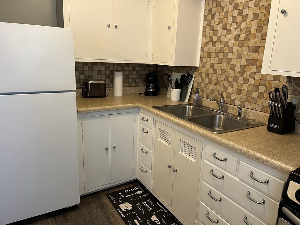 Kitchen w/essentials, microwave, stove, oven, refrigerator, freezer, coffee machine