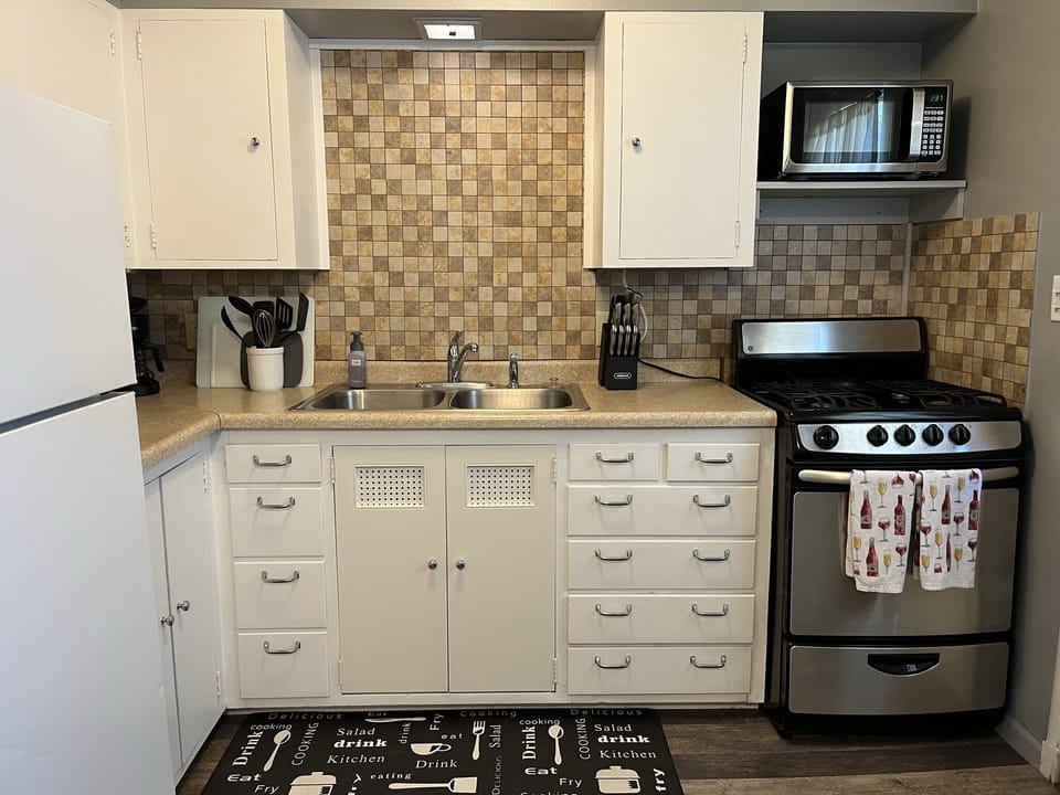 Kitchen w/essentials, microwave, stove, oven, refrigerator, freezer, coffee machine