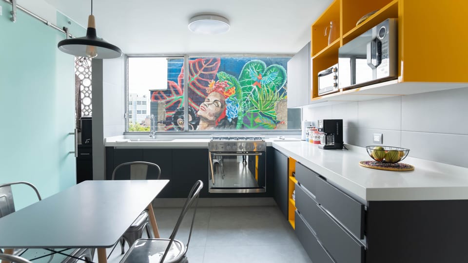 Kitchen, with view of mural outside. It also has a coffee maker and grinder