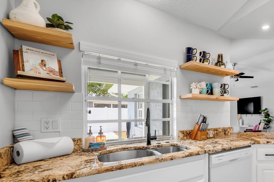 Mugs on the shelf, knives on the block, and a window over the sink for mornings
