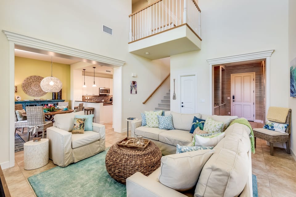 Open-concept living room with vaulted ceilings, plush seating, and natural light.