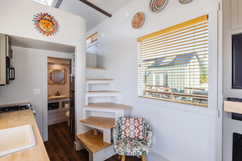 Kitchen cabinetry and counter space beneath a sunny window provide convenient storage and room for meal preparation.