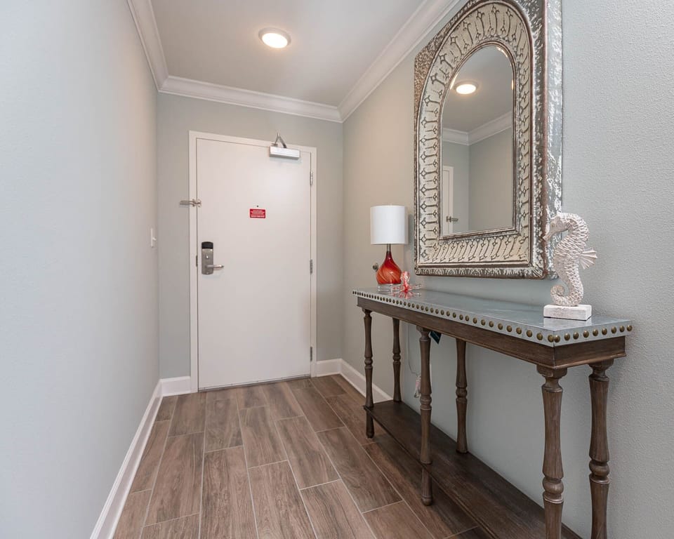 Step into a serene entryway featuring a stylish table and vibrant decor, setting a warm welcome for your getaway
