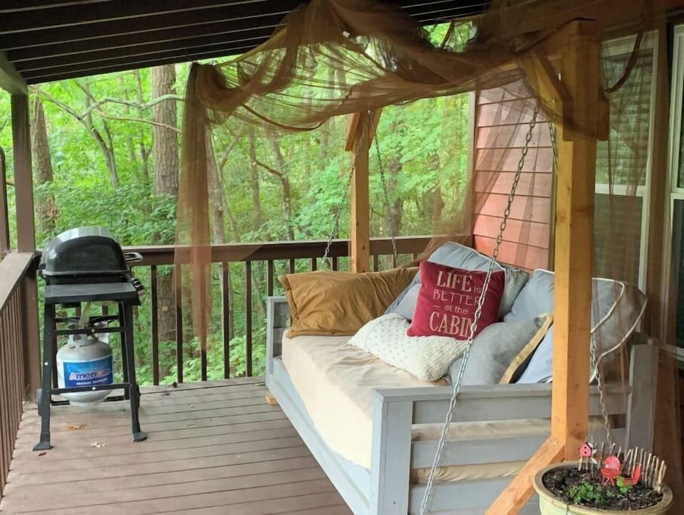 Large back porch with a day bed and grill.