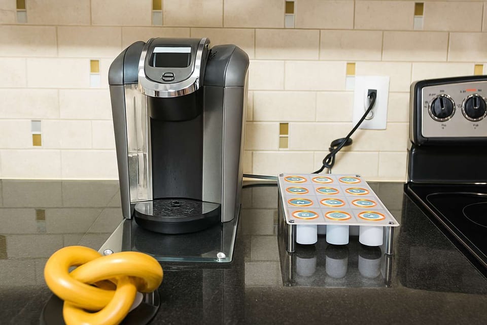 Kitchen counter with coffee maker, mugs, and storage drawers