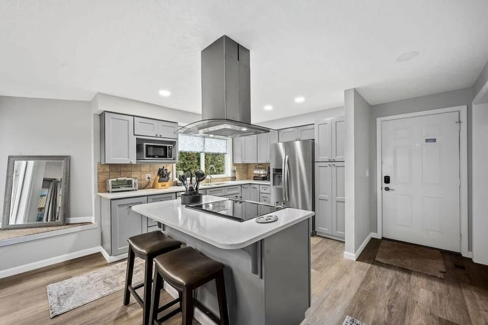 You'll love cooking in this sleek modern kitchen with stainless steel appliances, quartz countertops, and a convenient breakfast bar for casual dining.
