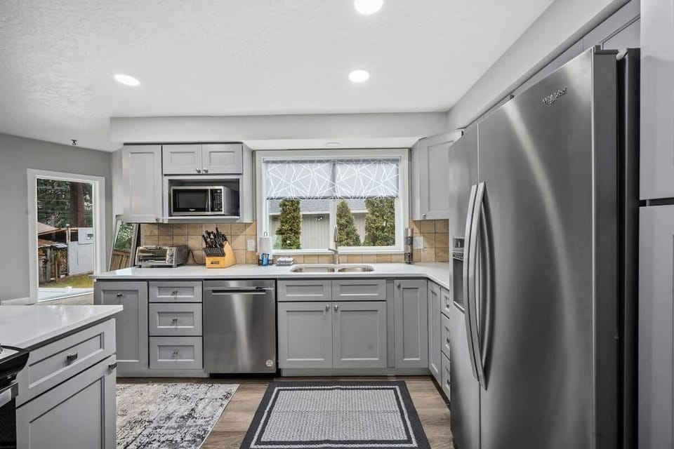 Cook your favorite meals in this modern kitchen featuring stainless steel appliances, ample counter space, and bright natural light streaming through windows.