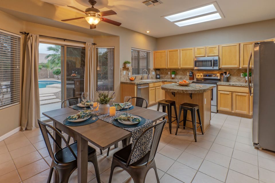 Doors between the kitchen and dining area access the backyard oasis with resort amenities.