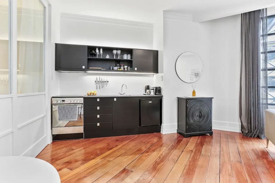 Cook up a storm in the sleek, fully equipped kitchen featuring modern black cabinetry and quality appliances, all set against the Heritage Hotel`s original polished timber floors.