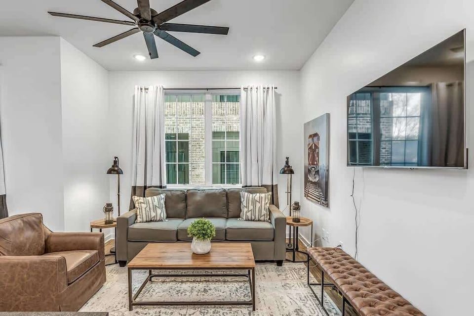 Open, airy living area with comfy seating and a wall-mounted Smart TV.